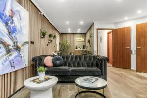 Una sala de estar con un sofá negro y una mesa. en Flyers Airport Hotel, en Keflavík