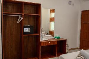 マシバリーにあるVelana View at Mathiveriのデスク、電子レンジ、鏡が備わる客室です。 +2枚の写真