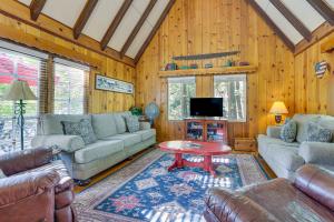 ein Wohnzimmer mit Sofas, Tisch und Fernseher in der Unterkunft Private Dock on Lake Arrowhead! Cozy Mtn Cabin in Lake Arrowhead