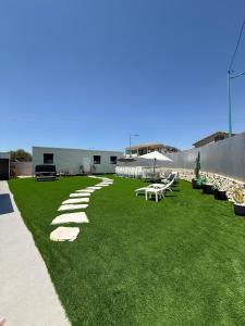 une pelouse avec une rangée de bancs dessus dans l'établissement אחוזת תכשיט, à Sifsufa