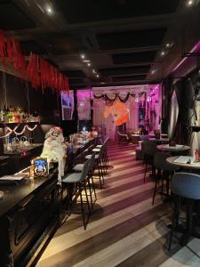 吉隆坡Ceylonz Suites by Stayla的餐厅配有桌椅和紫色照明