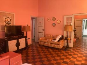 a living room with a couch and a flat screen tv at Lofts aconchegantes no Palácio Quitandinha in Petrópolis