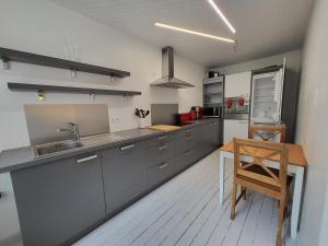 a kitchen with gray cabinets and a wooden table at Haus de Panne 6 bedrooms in De Panne