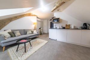 un soggiorno con divano e cucina di Villa Chadourne - LE CONQUERANT T2 Moderne a Brive-la-Gaillarde