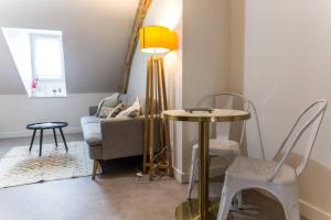 un soggiorno con un tavolo e un divano di Villa Chadourne - LE CONQUERANT T2 Moderne a Brive-la-Gaillarde Altre 13 foto