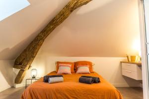 una camera con letto arancione e 2 cuscini di Villa Chadourne - LE CONQUERANT T2 Moderne a Brive-la-Gaillarde