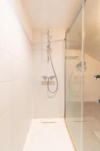 una doccia con una porta in vetro in un bagno di Villa Chadourne - LE CONQUERANT T2 Moderne a Brive-la-Gaillarde