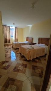 a hotel room with two beds and a tile floor at Hotel costa del Sol Marcona in San Juan de Marcona