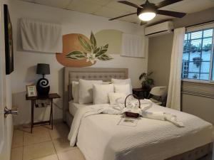 a bedroom with a bed with white sheets and a fan at Costa Verde Room With Private Bathroom in Alto de Limón