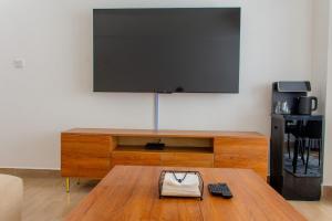 ein Wohnzimmer mit Fernseher und Couchtisch in der Unterkunft Waiyaki Way View Duplex Apartment in Nairobi