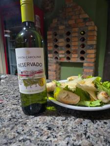 a bottle of wine next to a plate of food at Pousada Nonno Tranquilo - Chalé Sol, Lua, Estrela, Serra e Montanha in Lauro Müller +27 photos