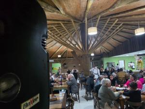 a group of people sitting at tables in a restaurant at Pousada Nonno Tranquilo - Chalé Sol, Lua, Estrela, Serra e Montanha in Lauro Müller