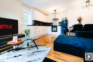 ein Wohnzimmer mit einem blauen Sofa und einem Tisch in der Unterkunft LUX 2BDR Flat in Woolwich I 2 Stops to Canary Wharf & Excel I Free Parking in Woolwich