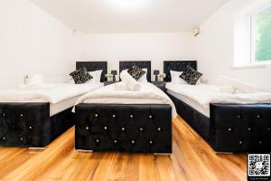 3 Betten in einem Zimmer mit Holzböden in der Unterkunft LUX 2BDR Flat in Woolwich I 2 Stops to Canary Wharf & Excel I Free Parking in Woolwich