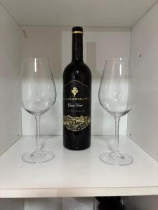 a bottle of wine and two wine glasses on a shelf at Benjamin 194 Suites in La Rioja