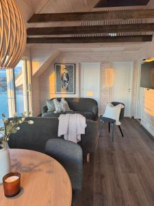 Rorbu med fantastisk utsikt i Brønnøysund في Salhus: غرفة معيشة بها أريكة وطاولة