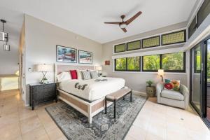 a bedroom with a bed and a couch and windows at Kapalua Ridge Villas 311 · KRV 311 Beautiful Kapalua Villa for W in Kahana +41 photos