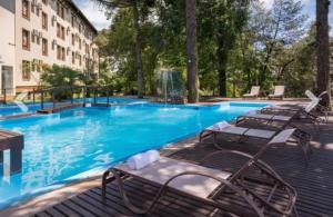 a large swimming pool with chairs and a building at Apartment no Wish Serrano 53 in Gramado