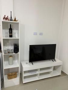 a white entertainment center with a flat screen tv at Benjamin 194 Suites in La Rioja