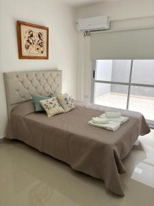 - une chambre avec un lit avec deux oreillers et une fenêtre dans l'établissement Benjamin 190 Suites, à La Rioja