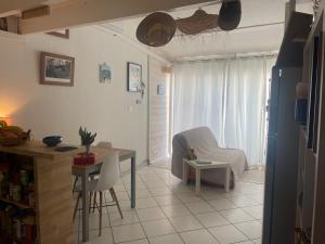 a living room with a table and a chair at Petite Maison Cocooning in Leucate-Plage