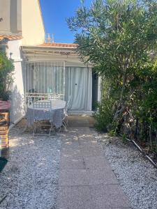 a patio with a table and chairs in front of a house at Petite Maison Cocooning in Leucate-Plage