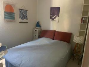a bedroom with a bed with red pillows on it at Petite Maison Cocooning in Leucate-Plage
