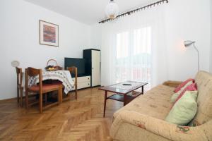ein Wohnzimmer mit Sofa und Tisch in der Unterkunft Apartman Mravinac in Tisno