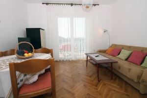 ein Wohnzimmer mit Sofa und Tisch in der Unterkunft Apartman Mravinac in Tisno