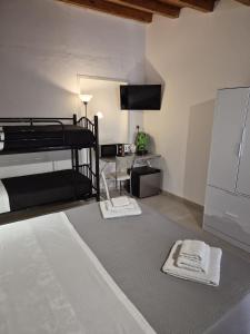 a bedroom with a bed and a desk and a tv at Cattedrale Central Rooms in Palermo