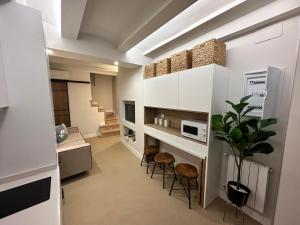 een keuken met witte kasten en krukken in een kamer bij Castillo 22 in Oropesa