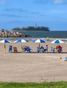 a group of chairs and umbrellas on a beach at Brisa Marina Departamento con Alberca y Playa in Boca del Río