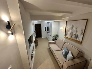 een woonkamer met een bank en een televisie bij Castillo 22 in Oropesa