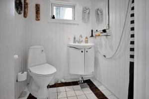 a white bathroom with a toilet and a sink at 15515-Asnaes-Klintebakken-10 in Høve Strand +22 photos
