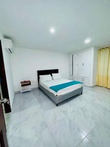 a bedroom with a large bed in a white room at Apartamento remodelado cómodo y cerca al mar in Cartagena de Indias +5 photos