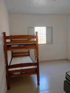 a wooden bunk bed in a room with a window at Chácara Mirante das Colinas in Atibaia