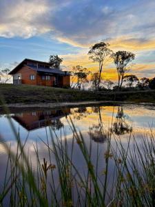 a house sitting next to a body of water at Cabana Romântica, Banheira, Lareira e Privacidade in Bom Retiro +31 photos