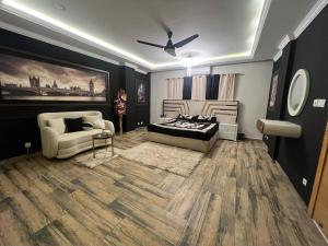 ein Schlafzimmer mit einem Bett, einer Couch und einem Sessel in der Unterkunft Modern 2BHK ApartmentPool Netflix in Rawalpindi