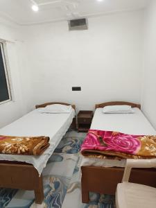 a room with two beds and a chair and a window at Shahi House in Bodh Gaya +26 photos