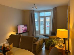 a living room with a couch and a tv at Apt 1, Whiterocks Portrush in Portrush