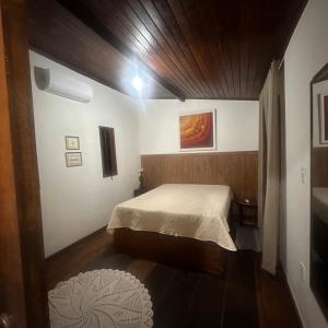 ein kleines Schlafzimmer mit einem Bett und einer Holzdecke in der Unterkunft Chalé da Mata in Cachoeiras de Macacu