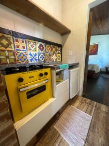 eine Küche mit einem gelben Herd in einem Zimmer in der Unterkunft Chalé da Mata in Cachoeiras de Macacu