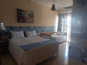 ein Schlafzimmer mit einem Bett und einem Stuhl darin in der Unterkunft Pousada São João Batista in Cachoeira Paulista