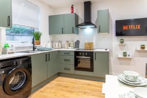 a kitchen with a washer and dryer in it at Cosy Corner in Derby