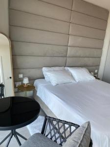 a bedroom with a white bed and a table at Mercury tower Elena K 24th panoramic view apartment in St Julian's