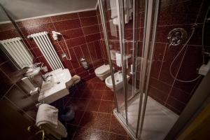 baño con 2 aseos y ducha acristalada en Hotel Spessotto, en Portogruaro