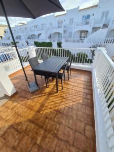 a patio with a table and chairs on a balcony at Acogedor apartamento a pasos de la playa in Arenal d'en Castell