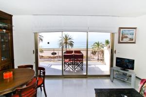 Sala de estar con mesa y vistas al océano en GOLF ST JORDI 2 Planet Costa Dorada, en Cambrils