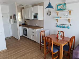 a kitchen and dining room with a table and chairs at Acogedor apartamento a pasos de la playa in Arenal d'en Castell