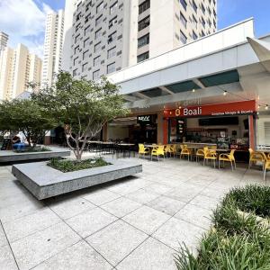 a restaurant with yellow tables and chairs in a city at Metropolitan Barcelona próximo Flamboyant e Autódromo in Goiânia
